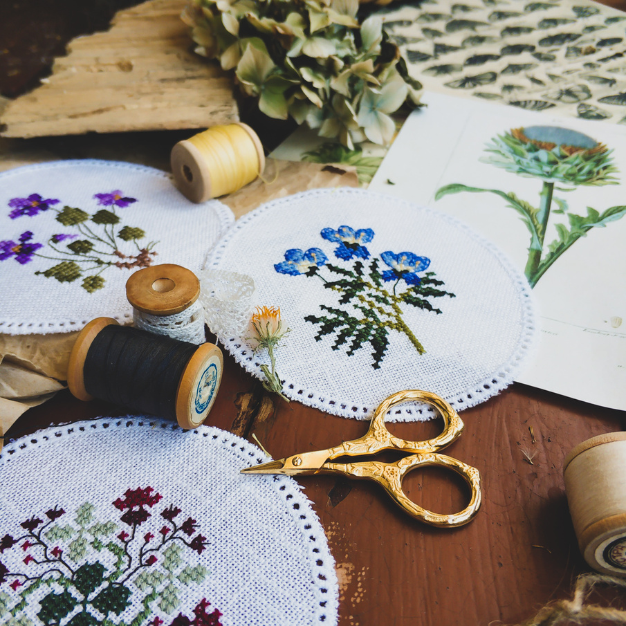 Collection of cross stitch embroidery and threads on table